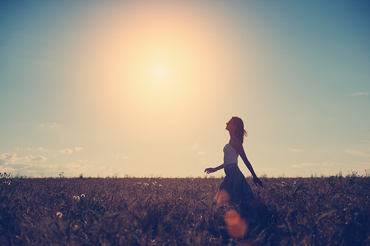 Girl walking in the field in the evening